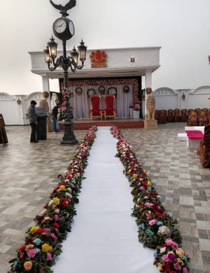 White aisle runner edged with multicoloured roses leading to a stage